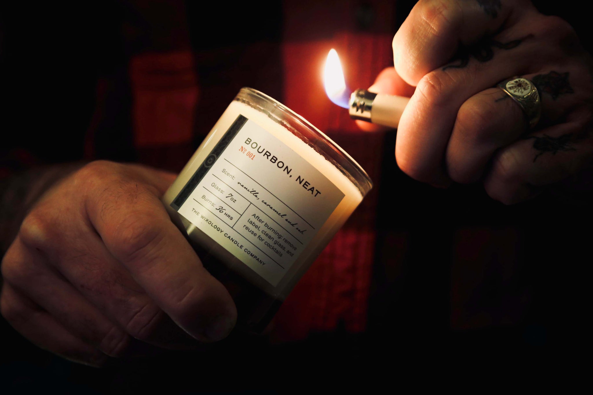 bourbon candle being lit by man in a flannel shirt
